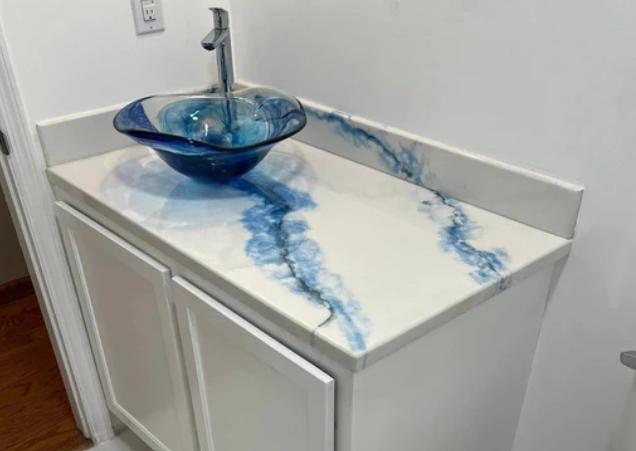 White vanity with blue resin river design countertop and glass bowl sink