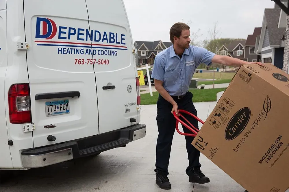 HVAC technician unloading a Carrier unit from a 