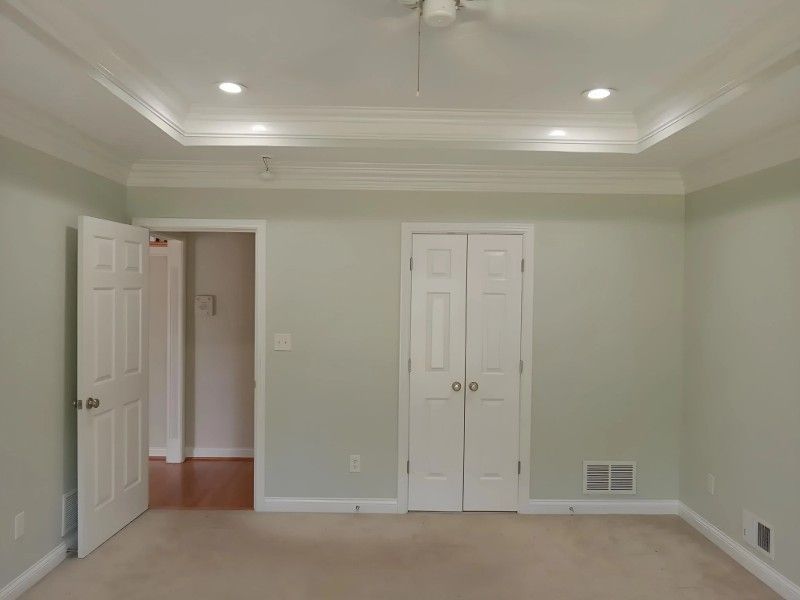 An empty room with two doors and a ceiling fan