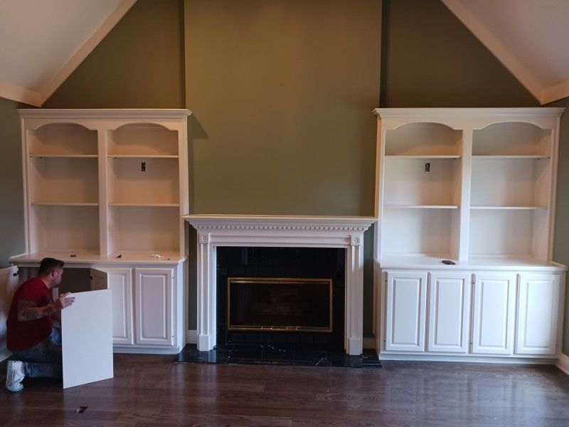 A man is working on a fireplace in a living room
