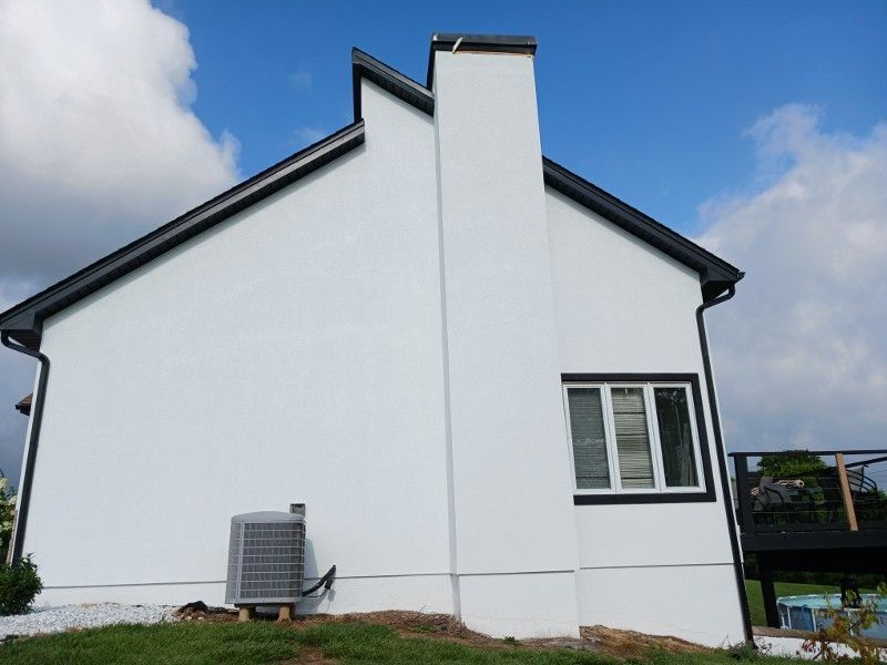 A white house with a chimney on the side of it