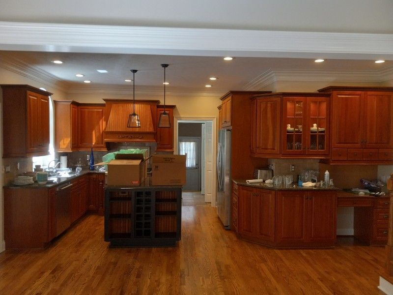A kitchen with wooden cabinets and boxes on the island