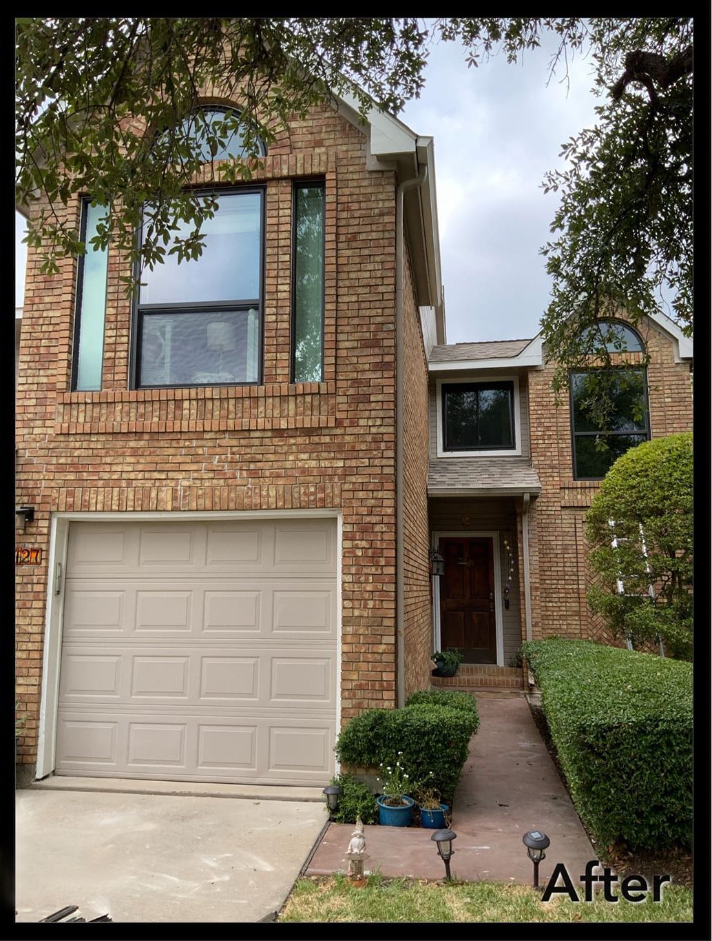 A picture of a brick house with a white garage door