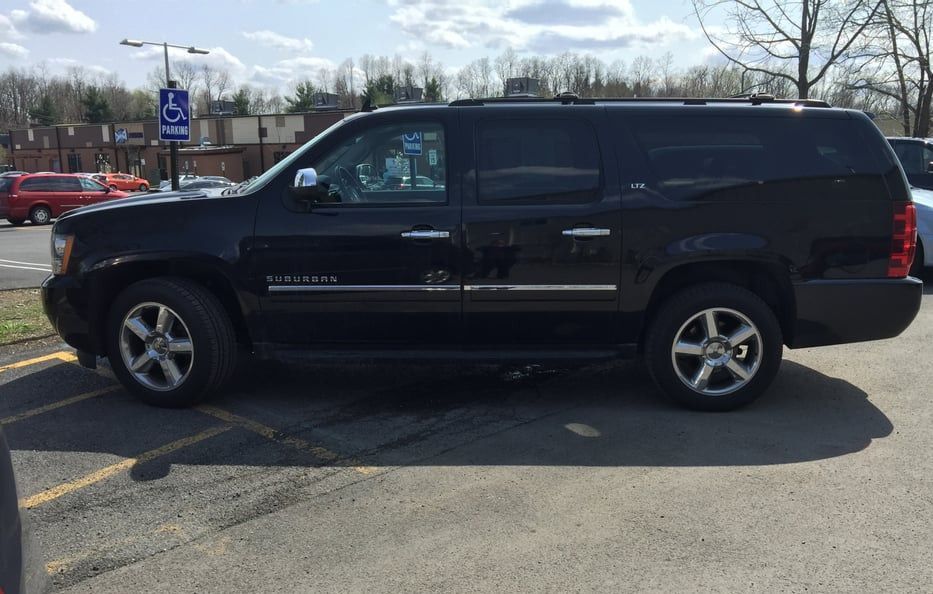 Black SUV parked in a lot on a sunny day