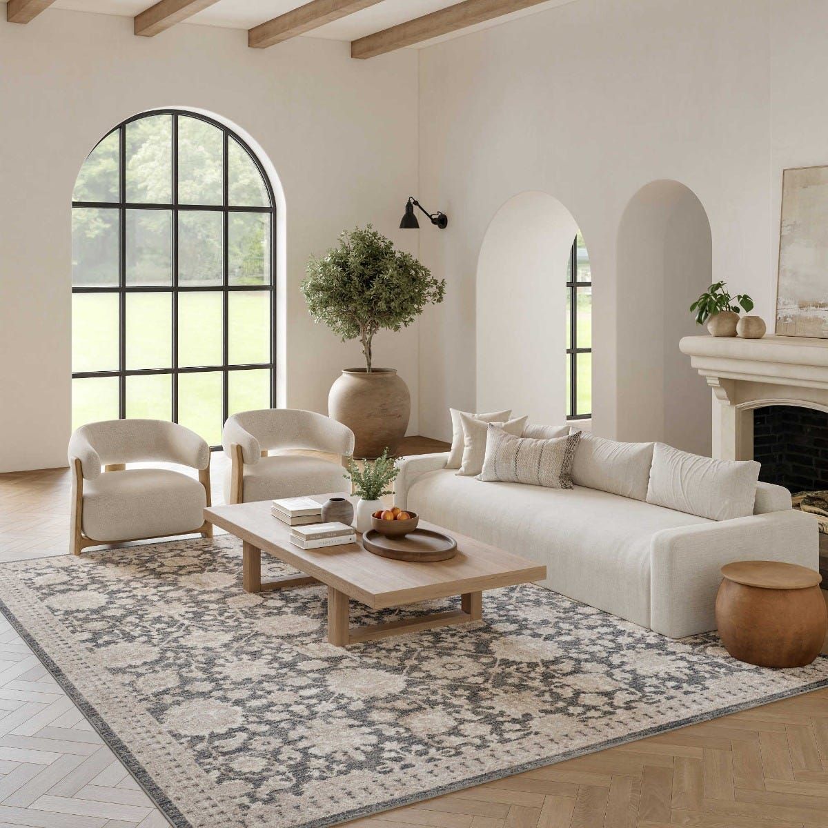 Minimalist living room with white sofa, arched windows, and patterned rug in neutral tones