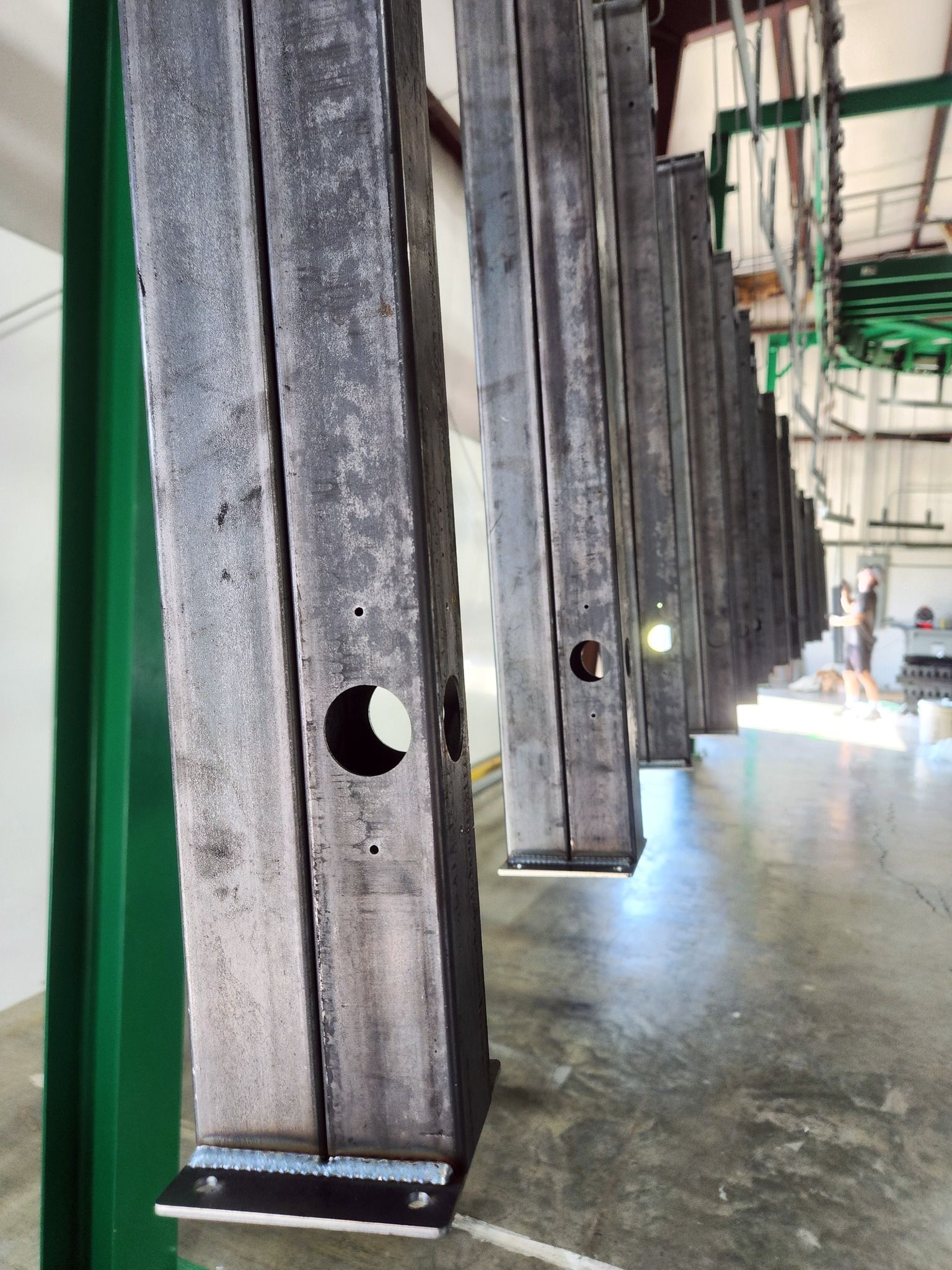 Industrial workshop with hanging dark metal panels and one circular hole in the foreground