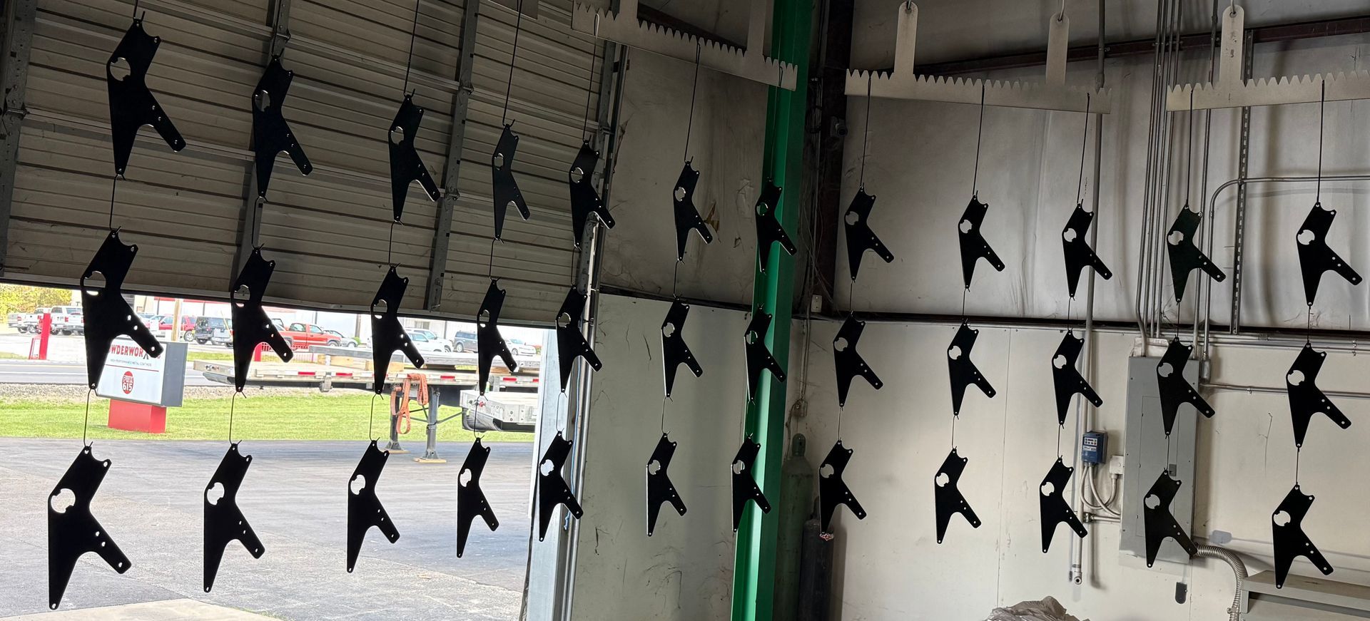 Rows of black bird-shaped hanging decorations in a windowed indoor space