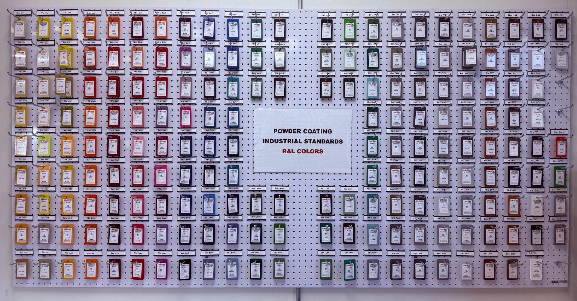 Wall of multiple small labeled compartments in rows, with a central sign and color-coded sections.