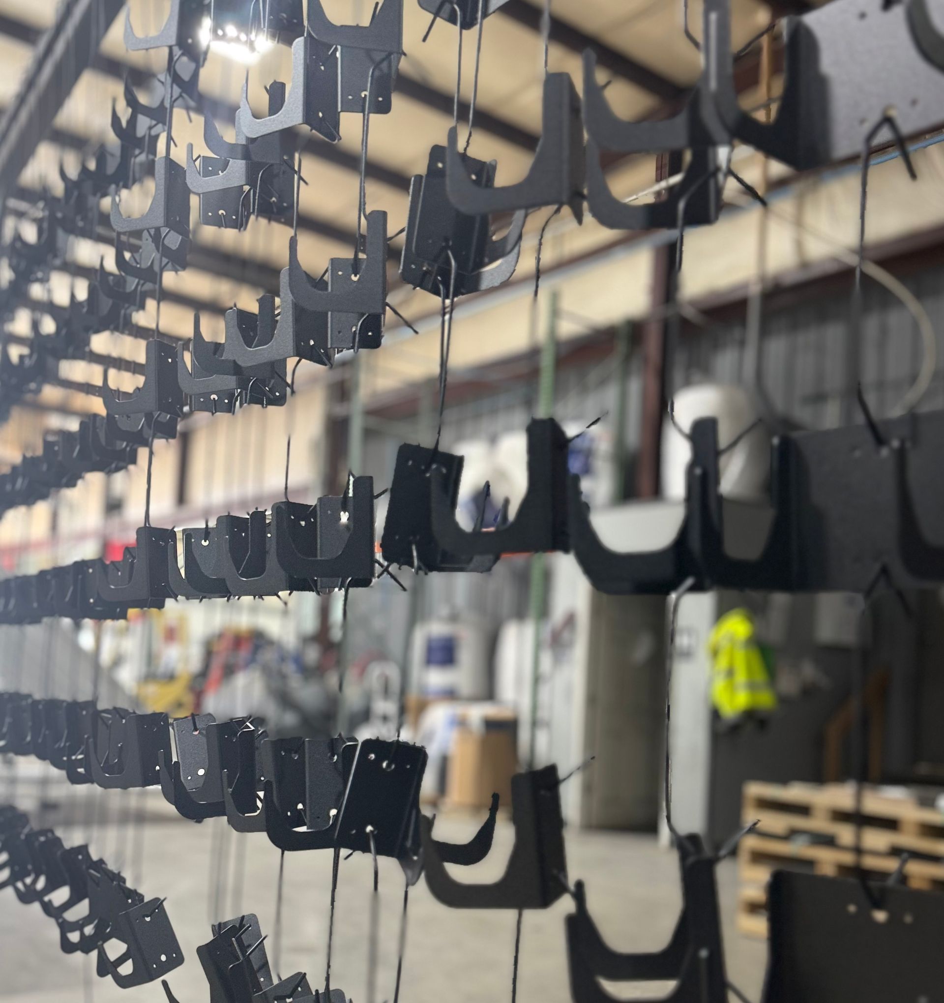Rows of black hanging parts on an industrial production line in a factory