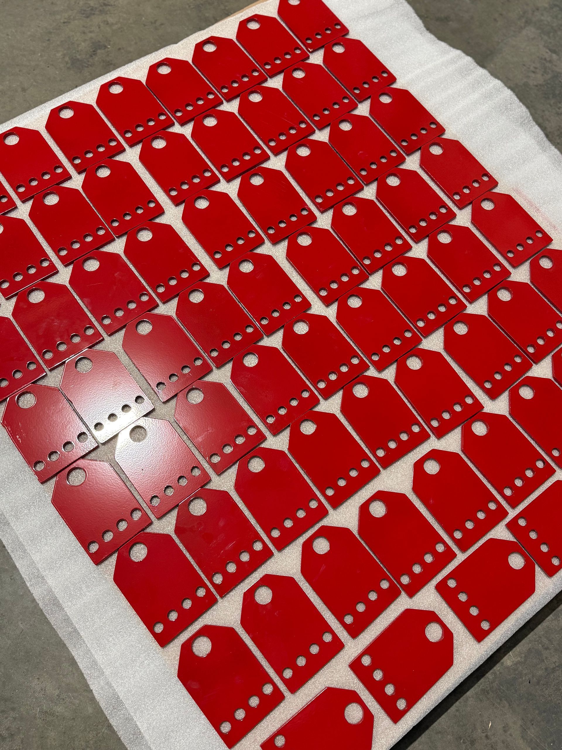 Rows of red domino tiles with white dots arranged in a diamond pattern on a floor.