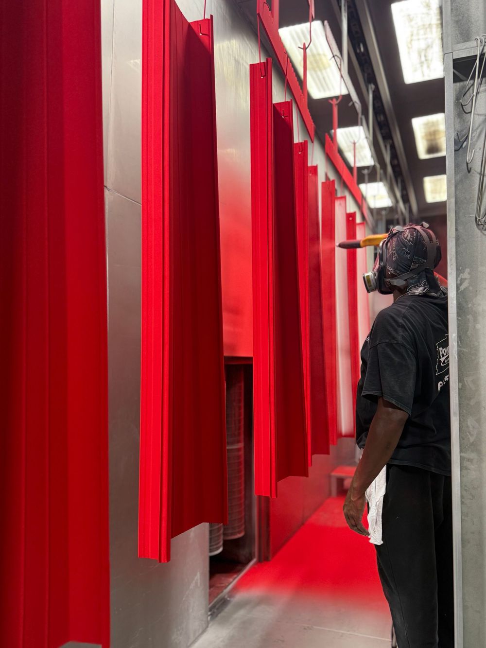 Person walking through a red-lit corridor with hanging red panels and a ceiling-mounted camera rig