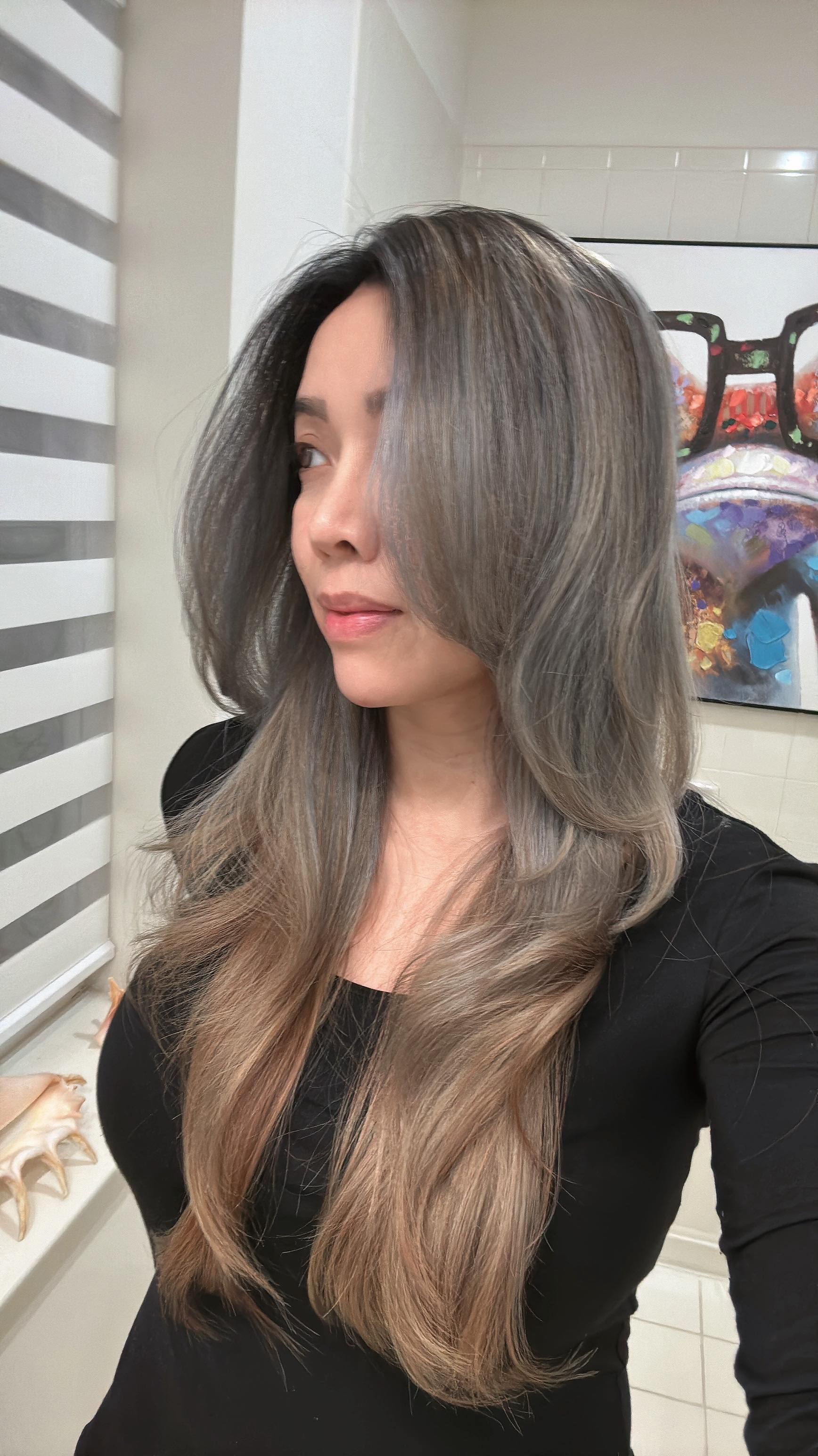 a woman with long gray hair is taking a selfie