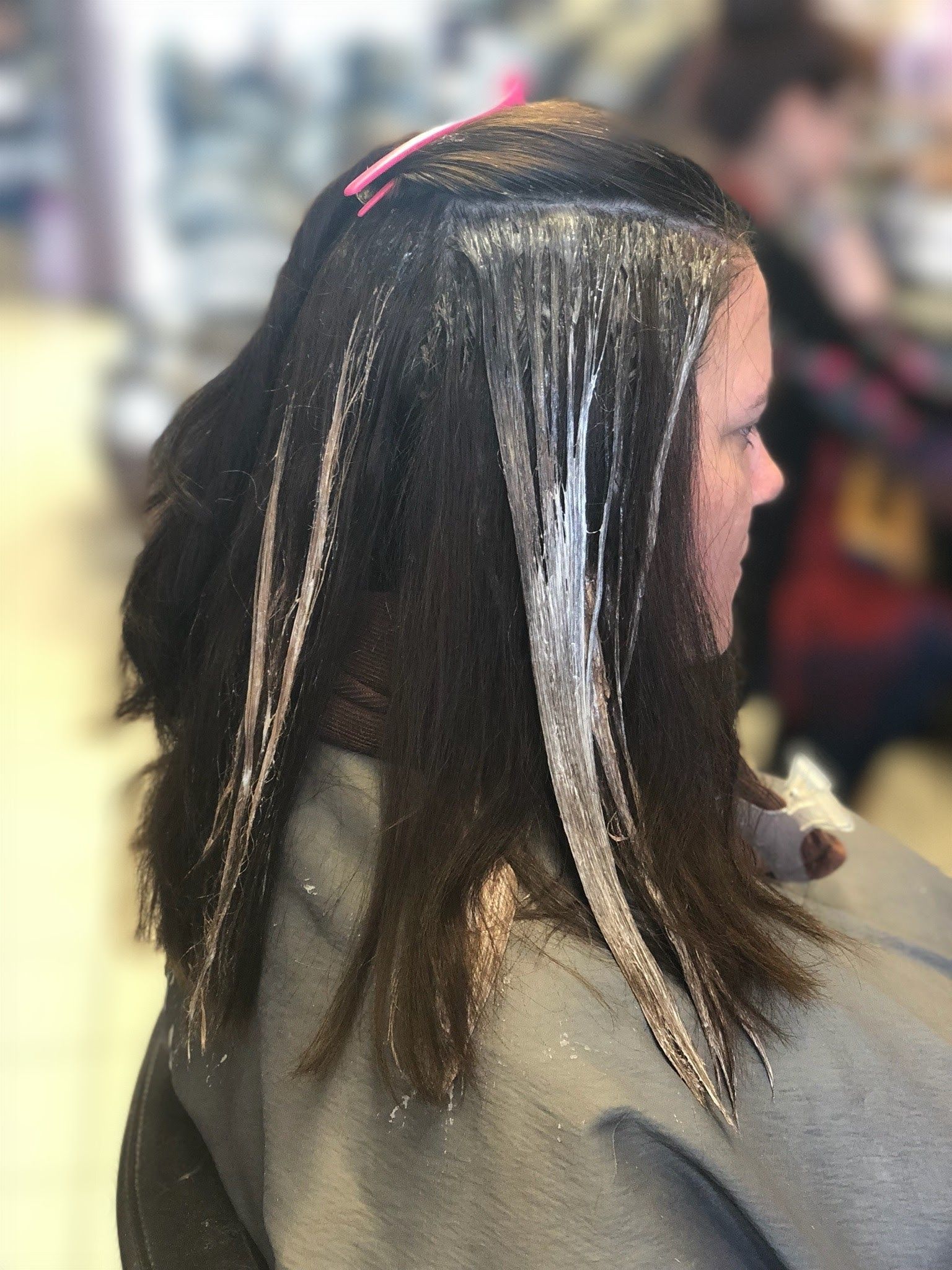 a woman is getting her hair dyed in a salon