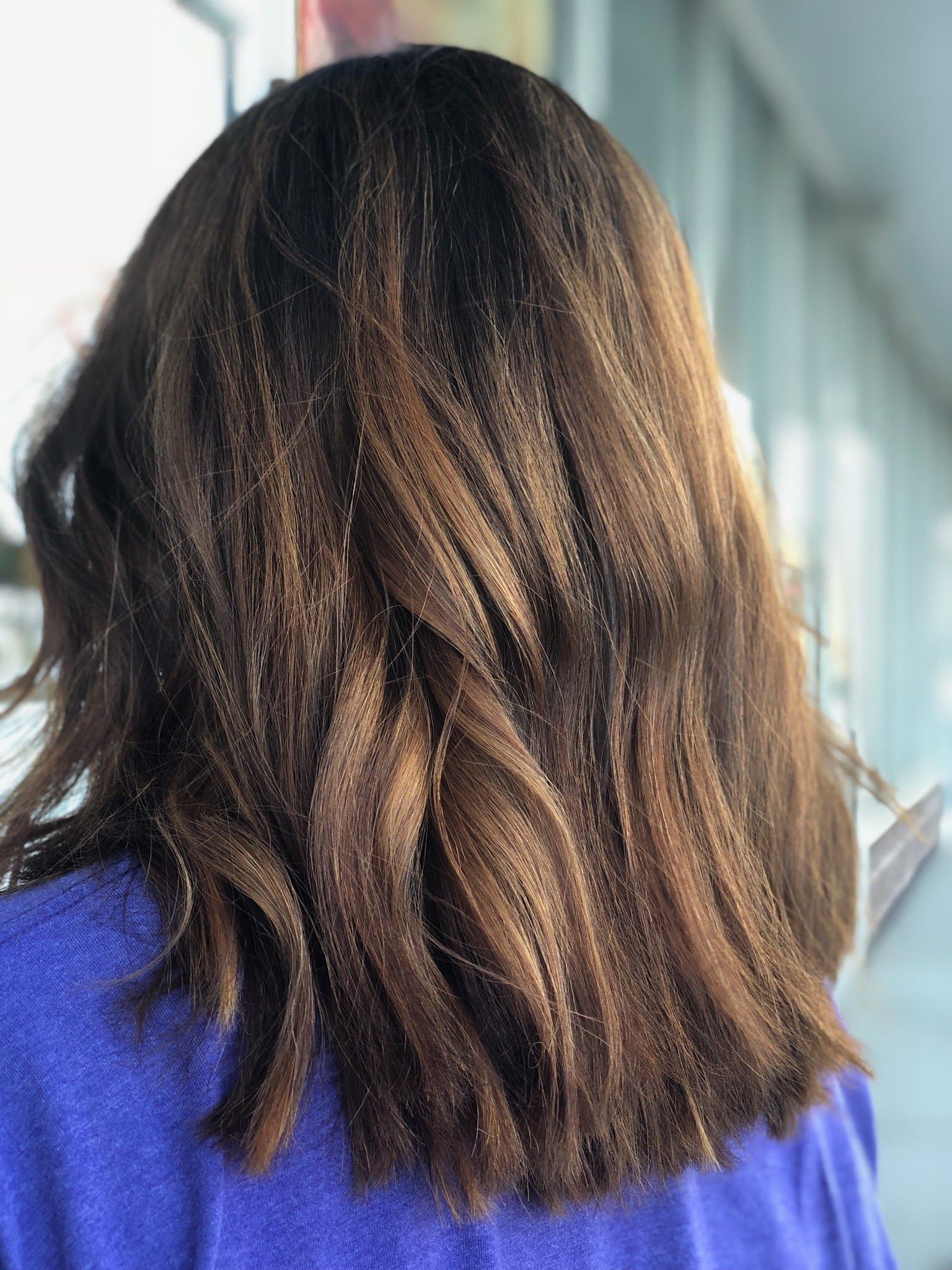 a woman with long brown hair is wearing a purple shirt