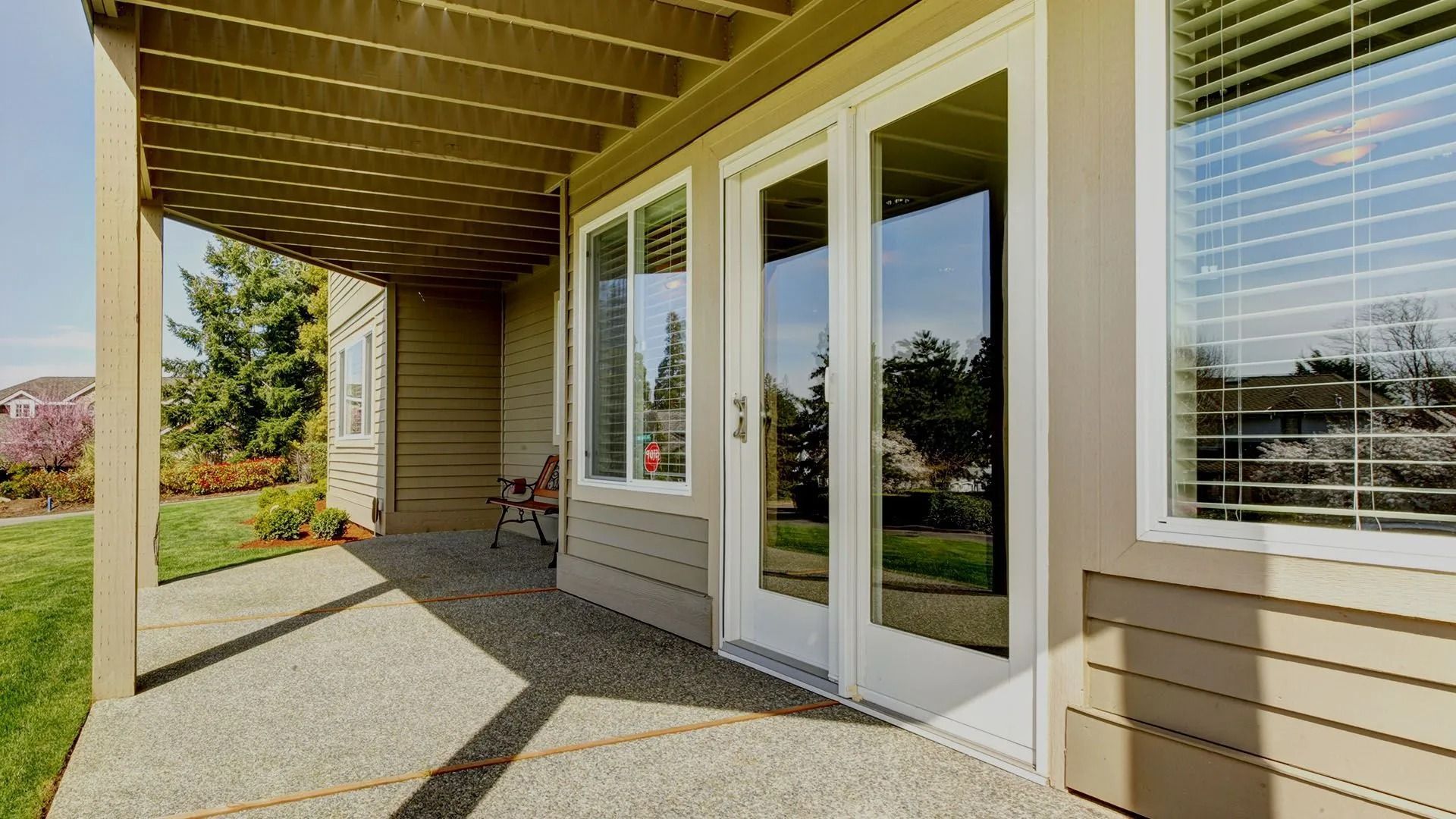 There is a patio with sliding glass doors and a pergola.