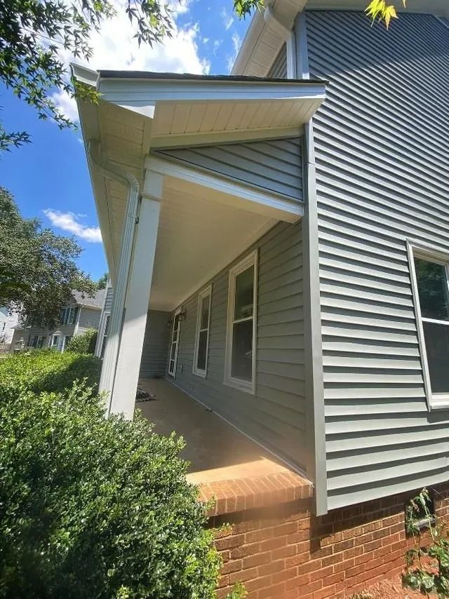 A house with a porch and a lot of windows.