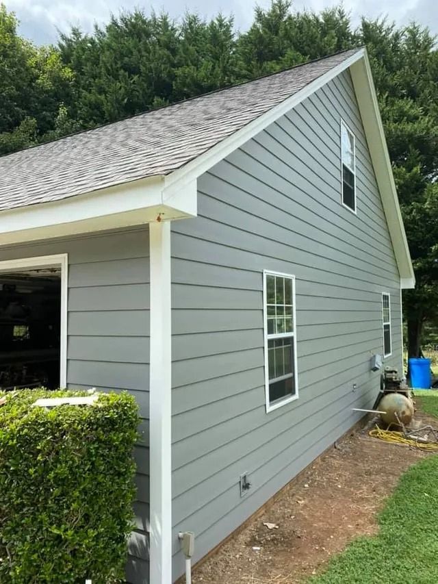 The side of a house with a garage and a roof.