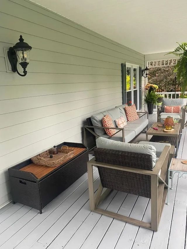 A porch with a couch , chairs and a coffee table