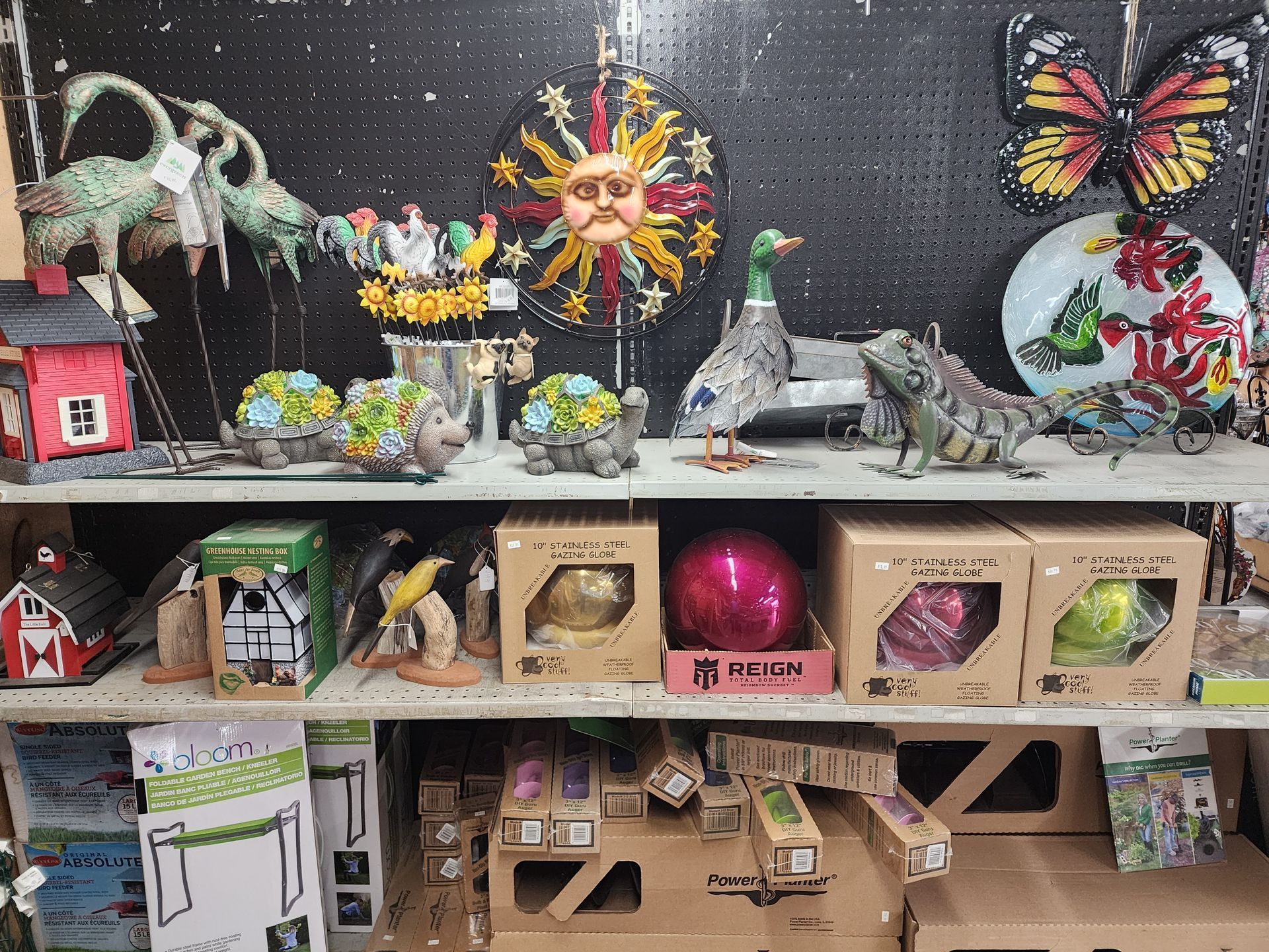 Colorful handmade diorama with animals, butterflies, and small decorated boxes on shelves