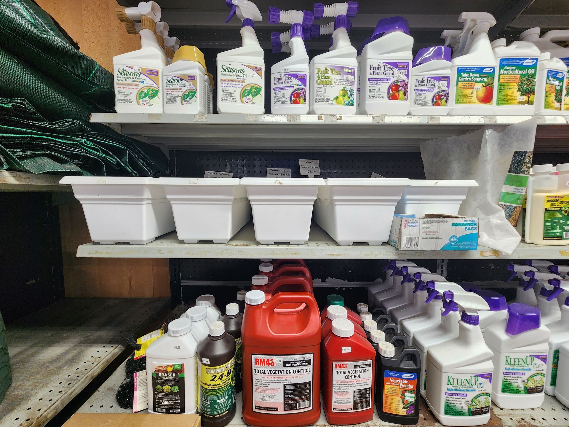 Shelves of assorted gardening and cleaning bottles and tubs in a storage area