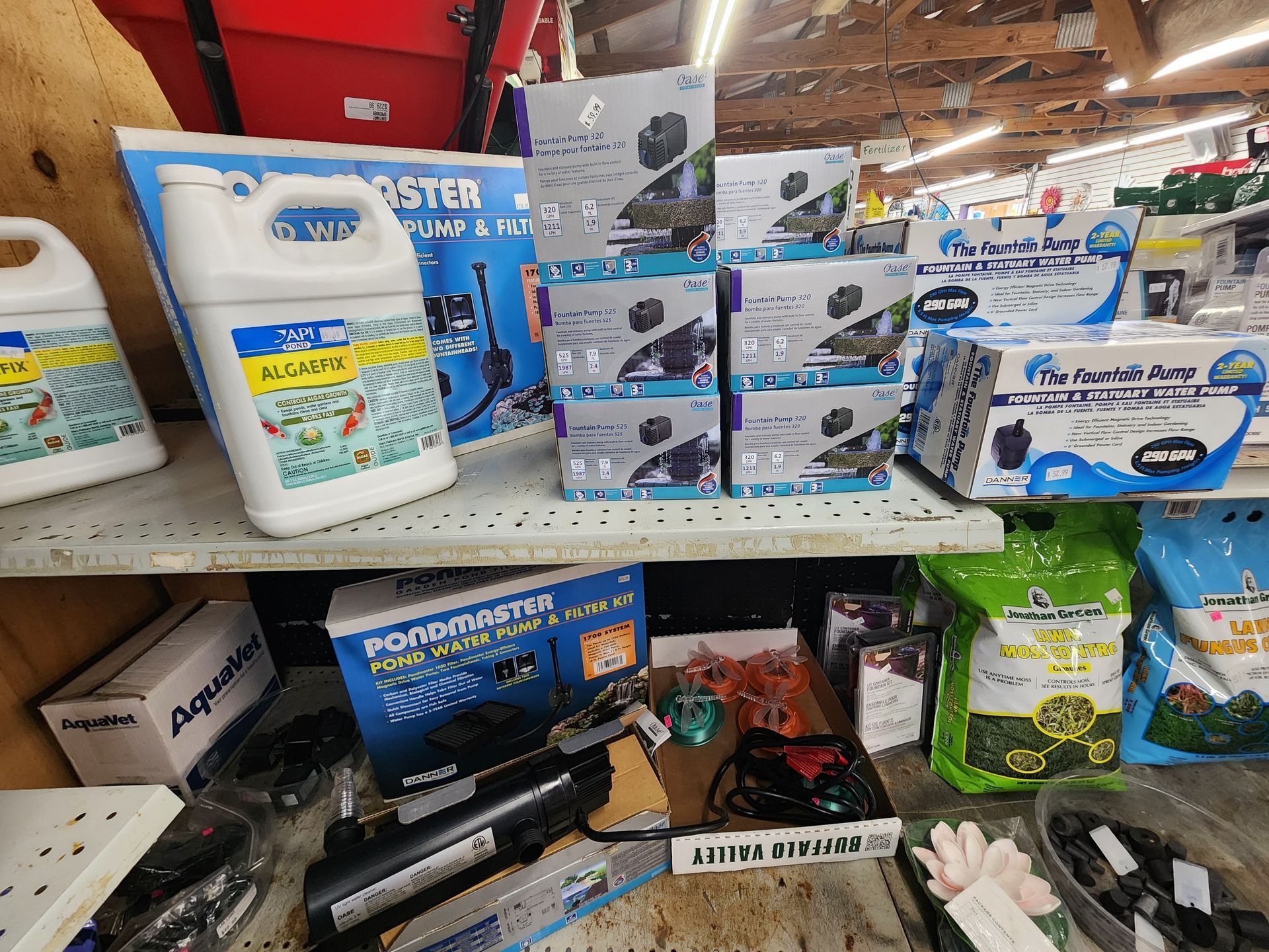 Store shelf with cat litter, pet supplies, and small product boxes in a retail aisle.