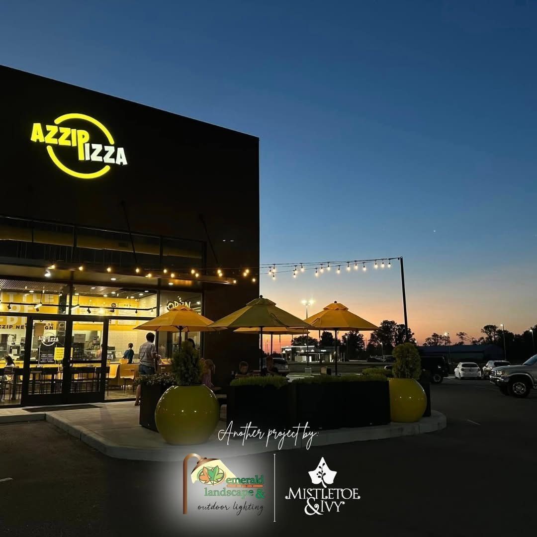 AZZIP Pizza restaurant exterior at dusk with yellow umbrellas and logo.