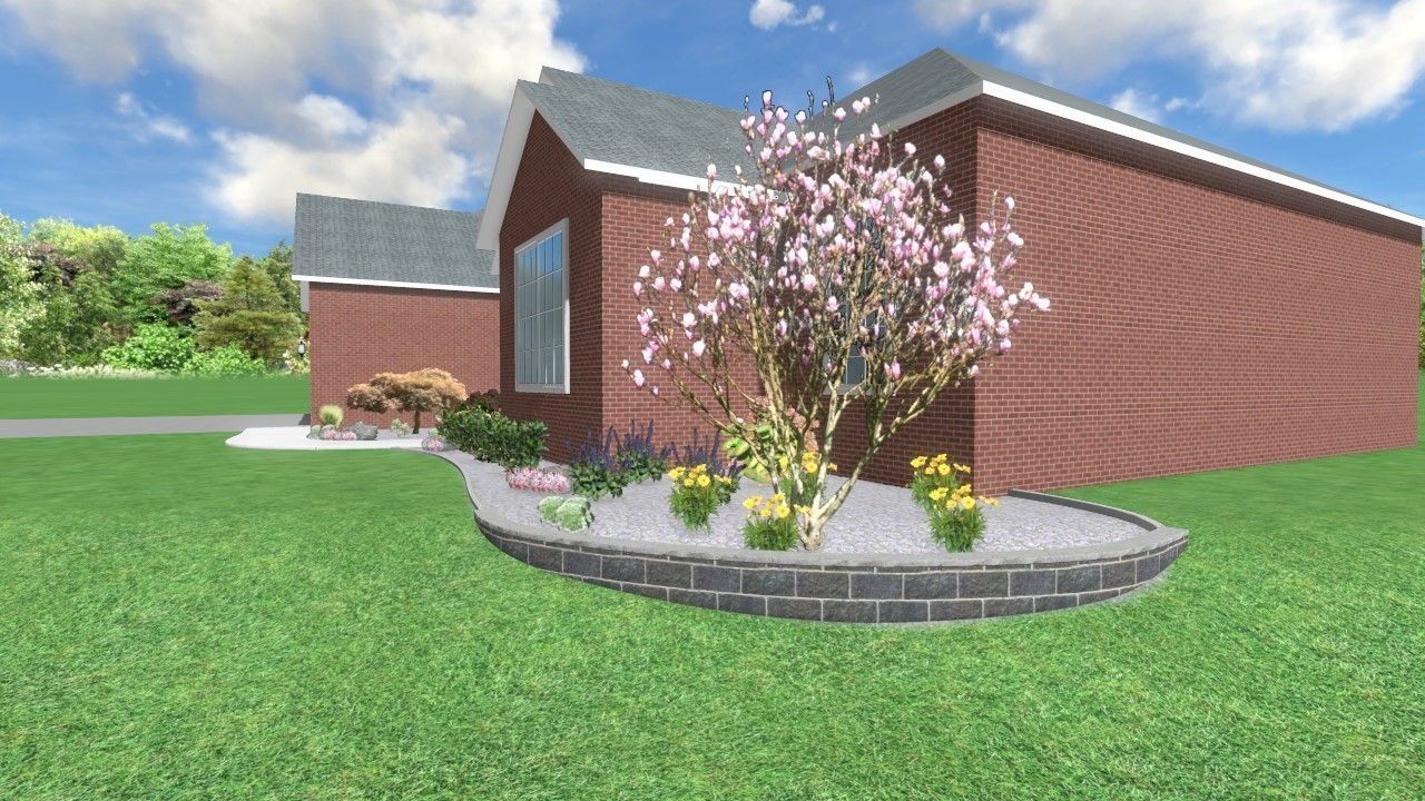 Brick house with landscaping, a flowering tree, and a curved border of gray bricks.