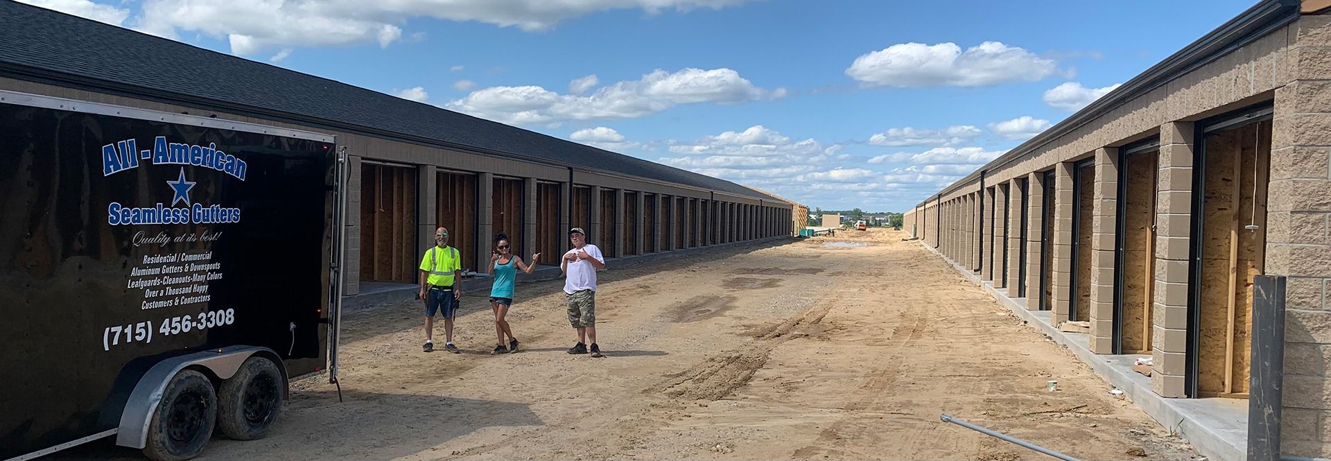 Outdoor stable corridor with three people walking toward the horizon under a blue sky