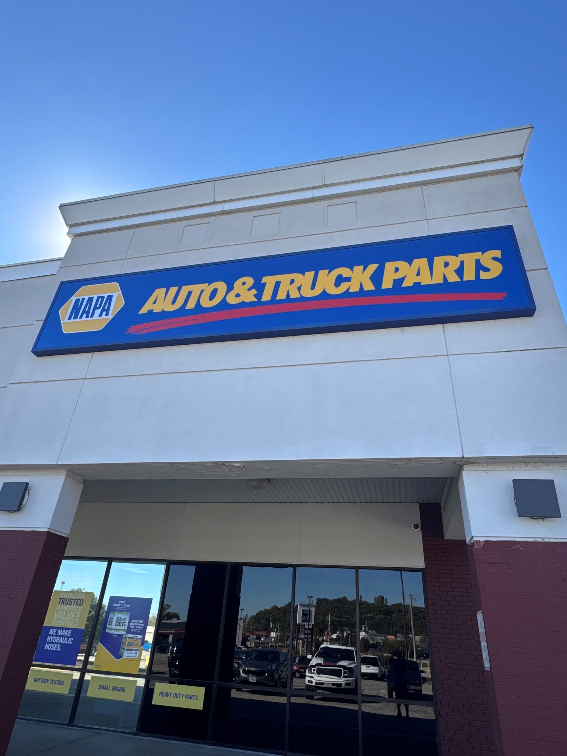 NAPA Auto & Truck Parts storefront with blue and yellow sign above glass entrance