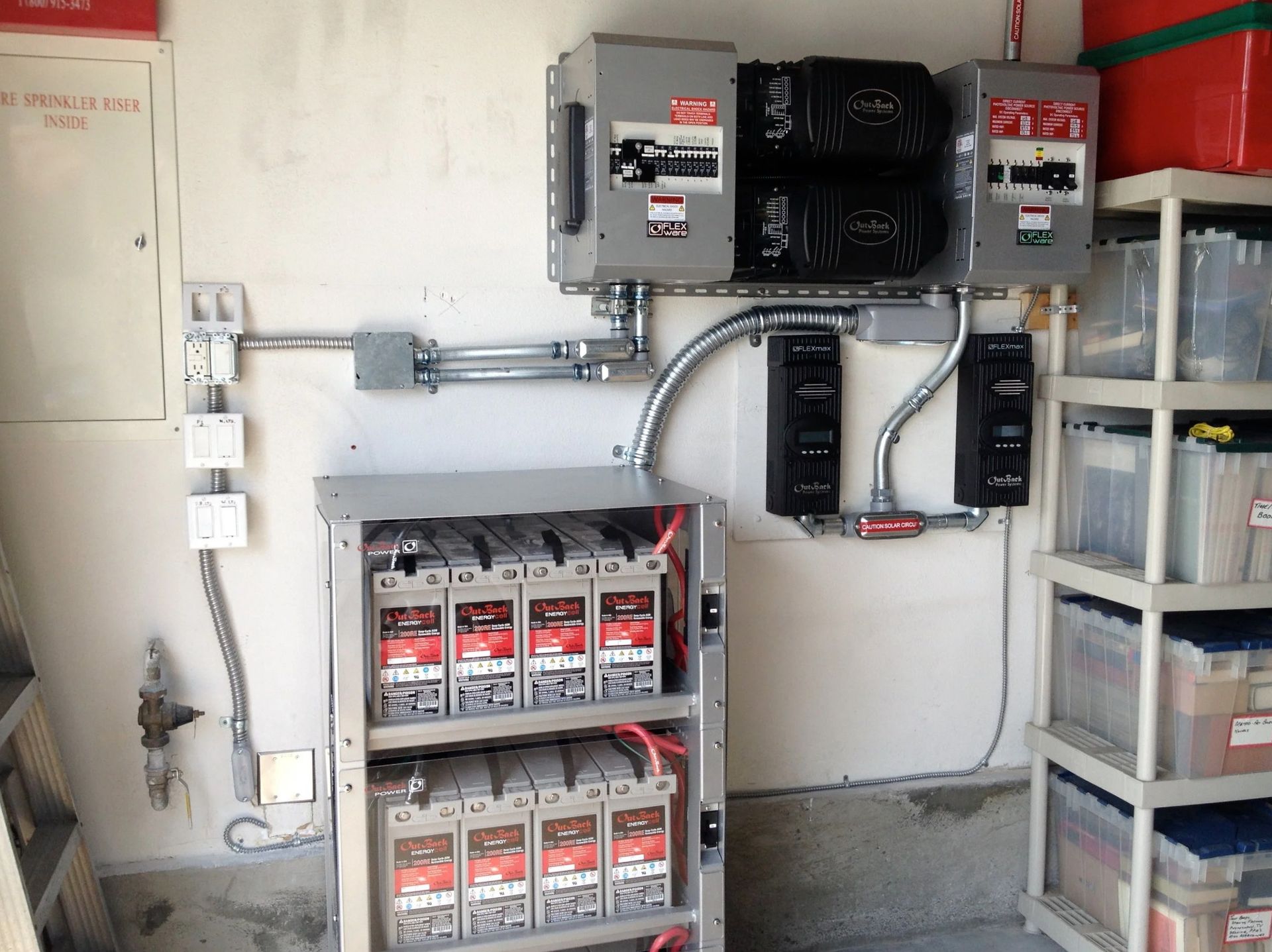 Electrical utility room with breaker panels, conduit, and stacked equipment on shelves