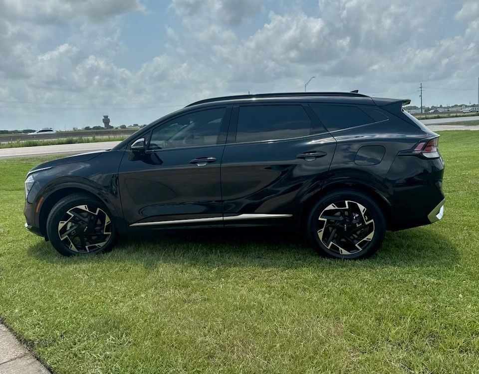 A black suv is parked on top of a lush green field.