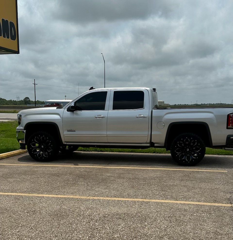 A silver truck is parked in a parking lot