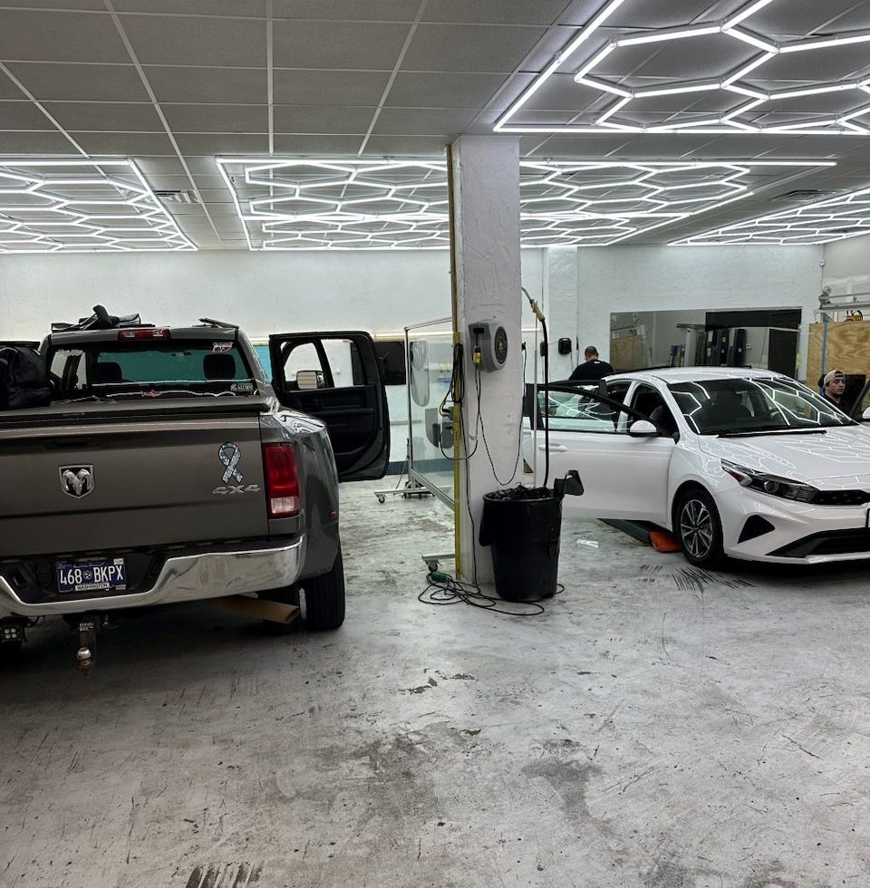 A truck and a car are parked in a garage.