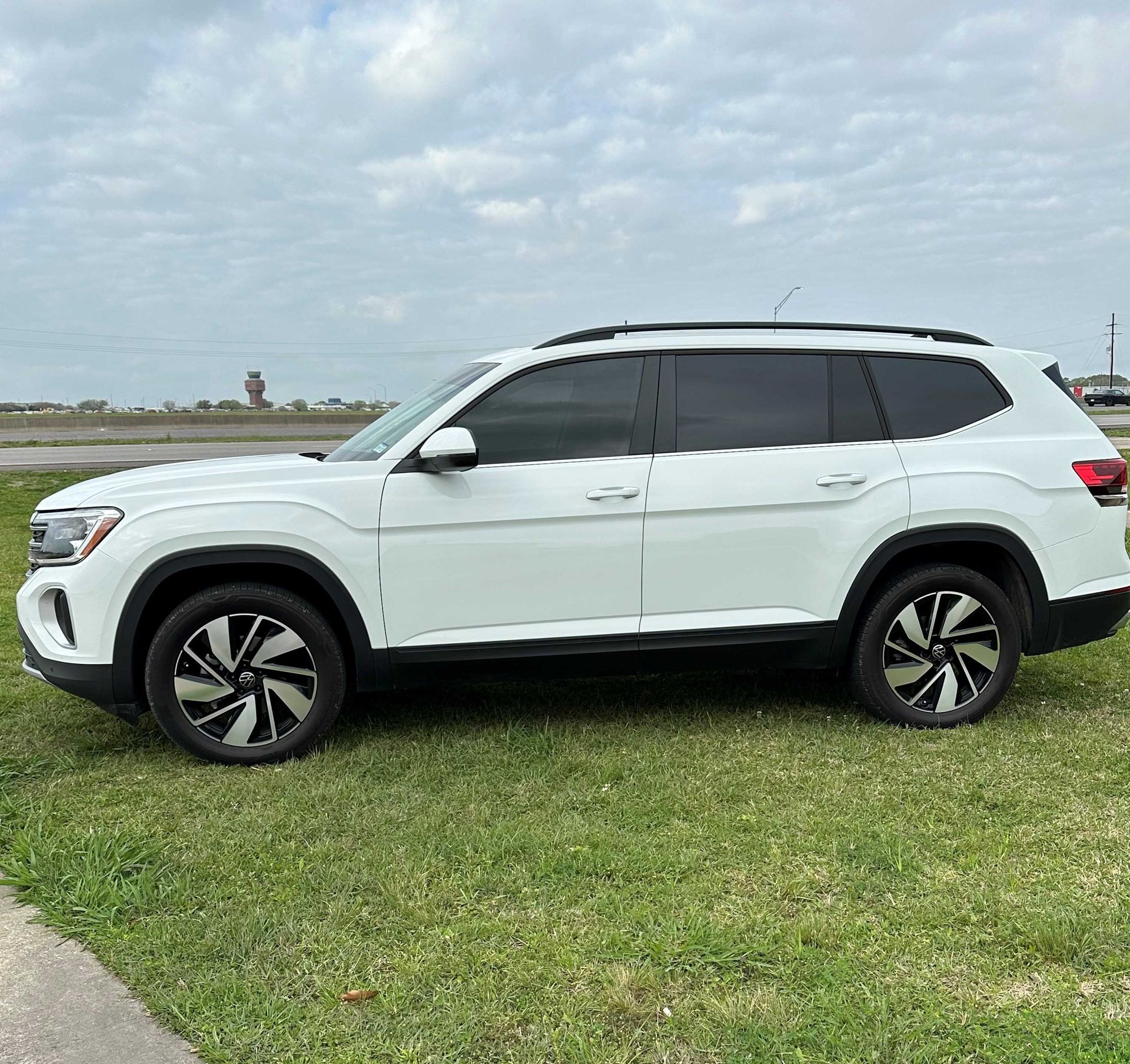 A white suv is parked in a grassy field.
