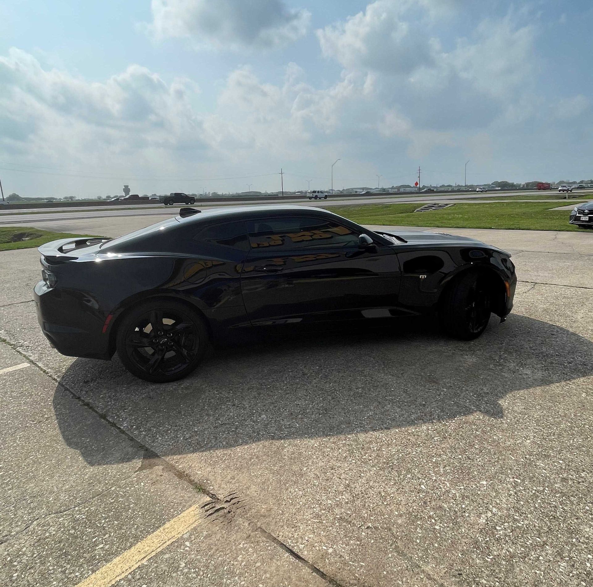 A black car is parked on the side of the road