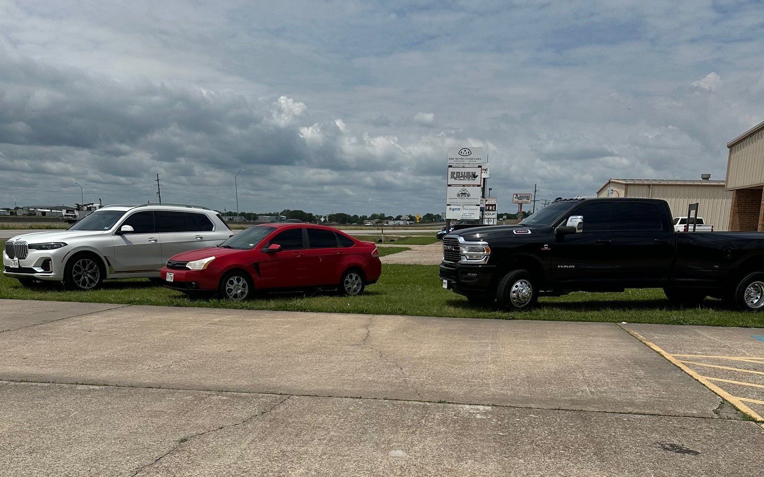 Three cars and a truck are parked in a parking lot.