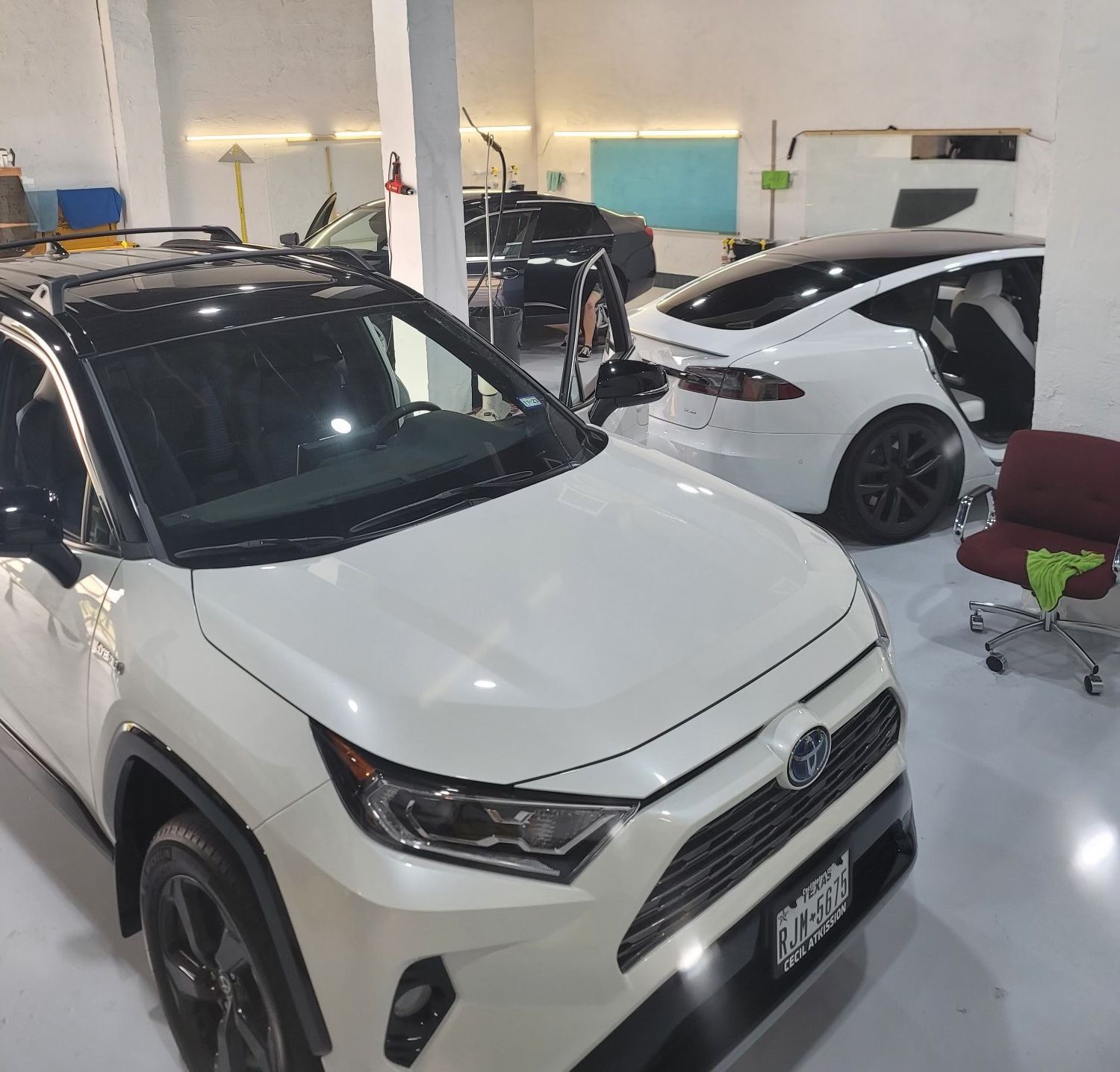 A white toyota rav4 is parked in a garage