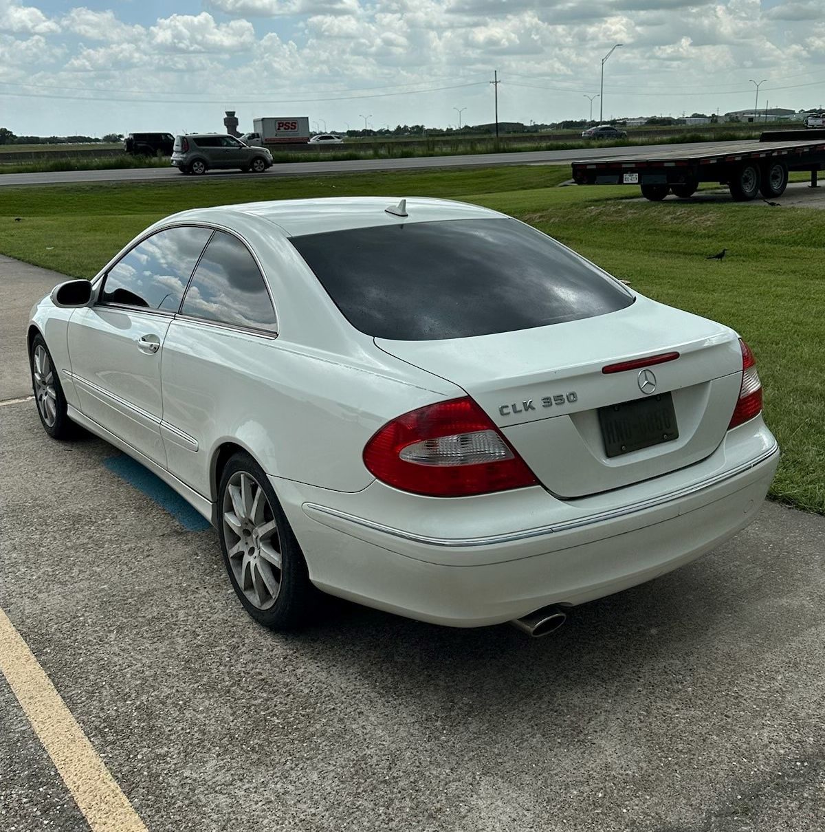 A white car is parked on the side of the road