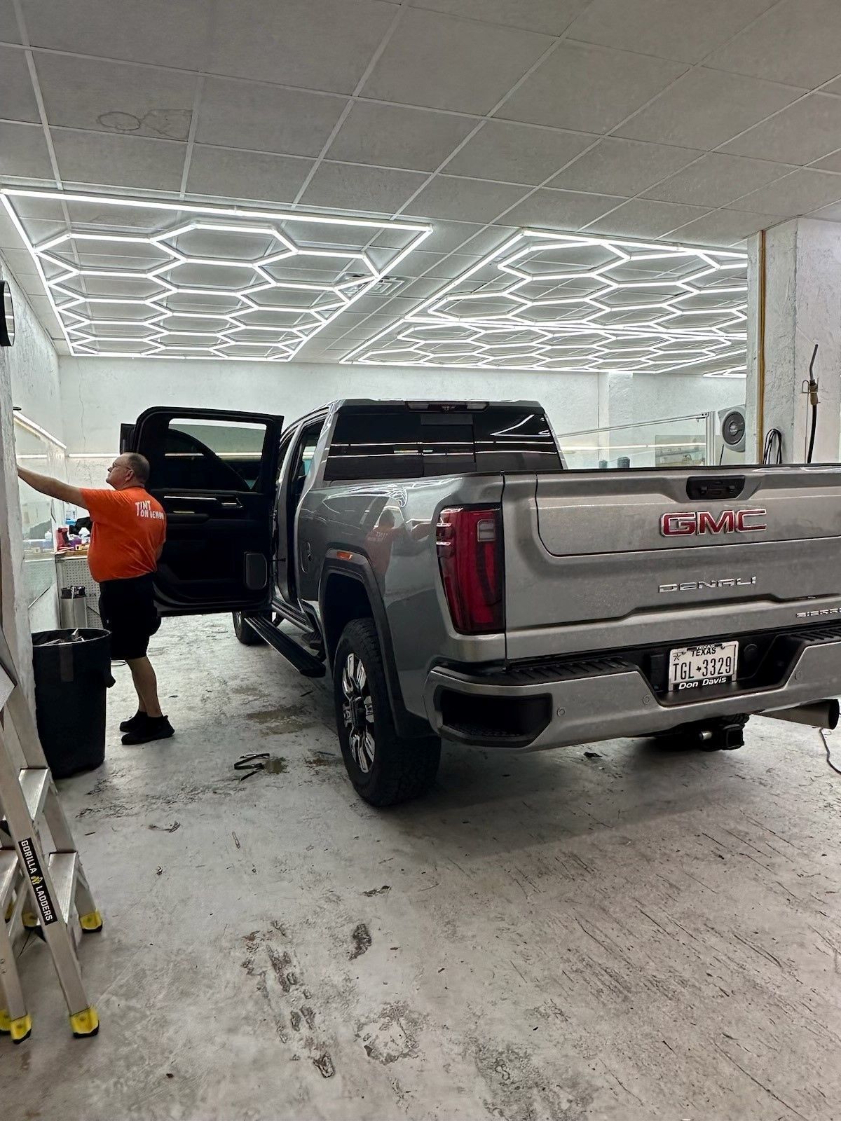 A man is working on a truck in a garage.