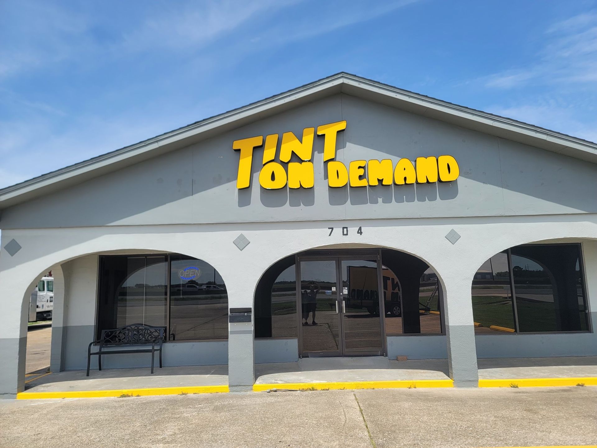 A building with a yellow sign that says tint on demand