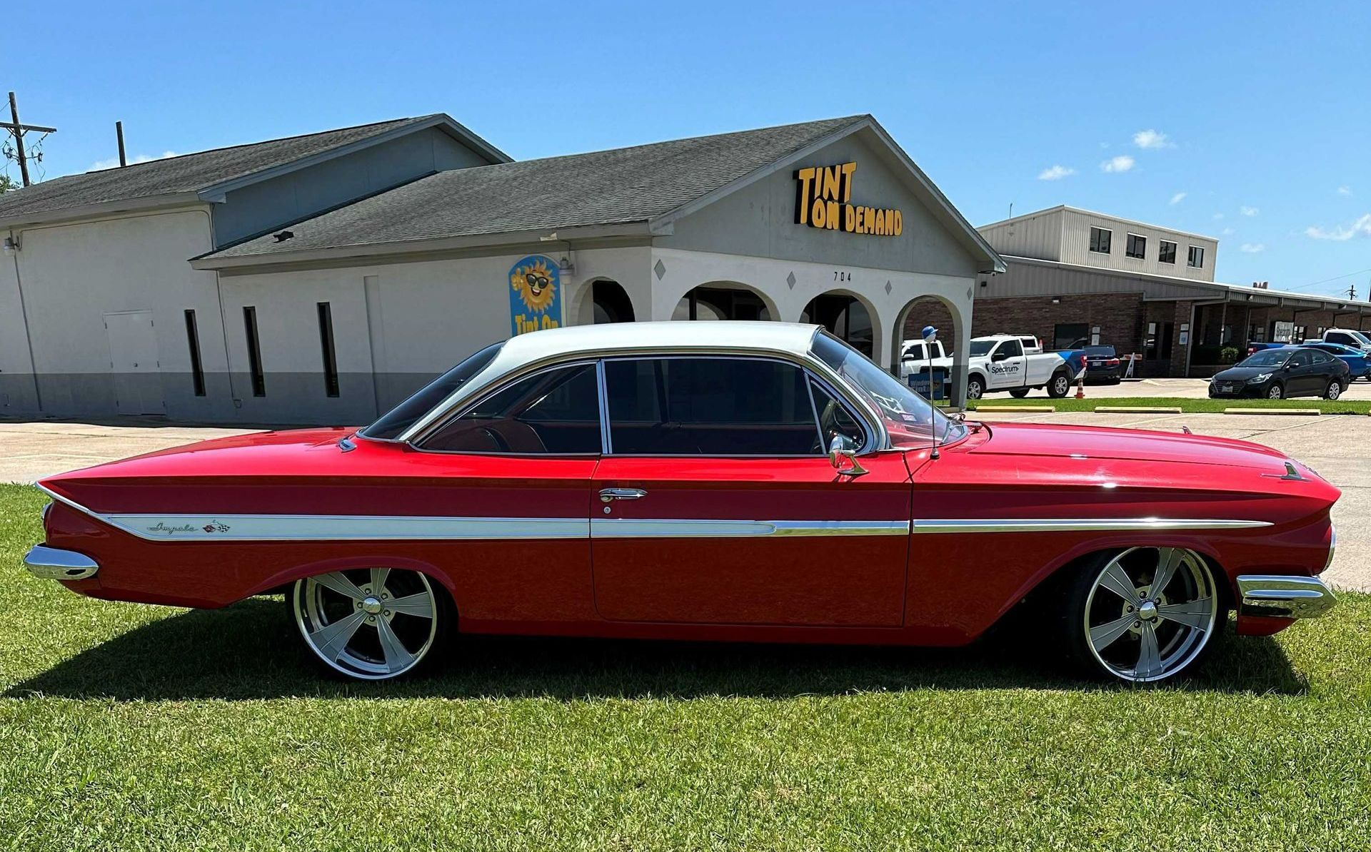 A red car is parked in front of a building.