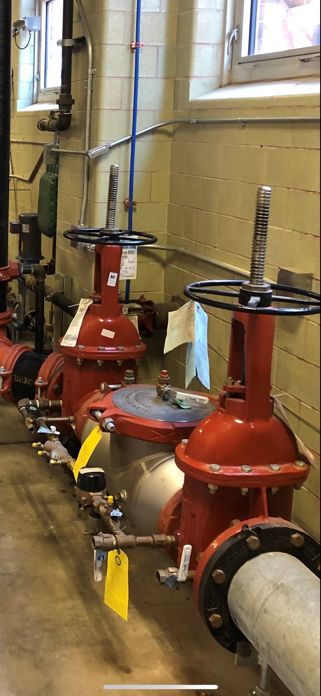 Red industrial valves and piping, likely for water supply in a building.