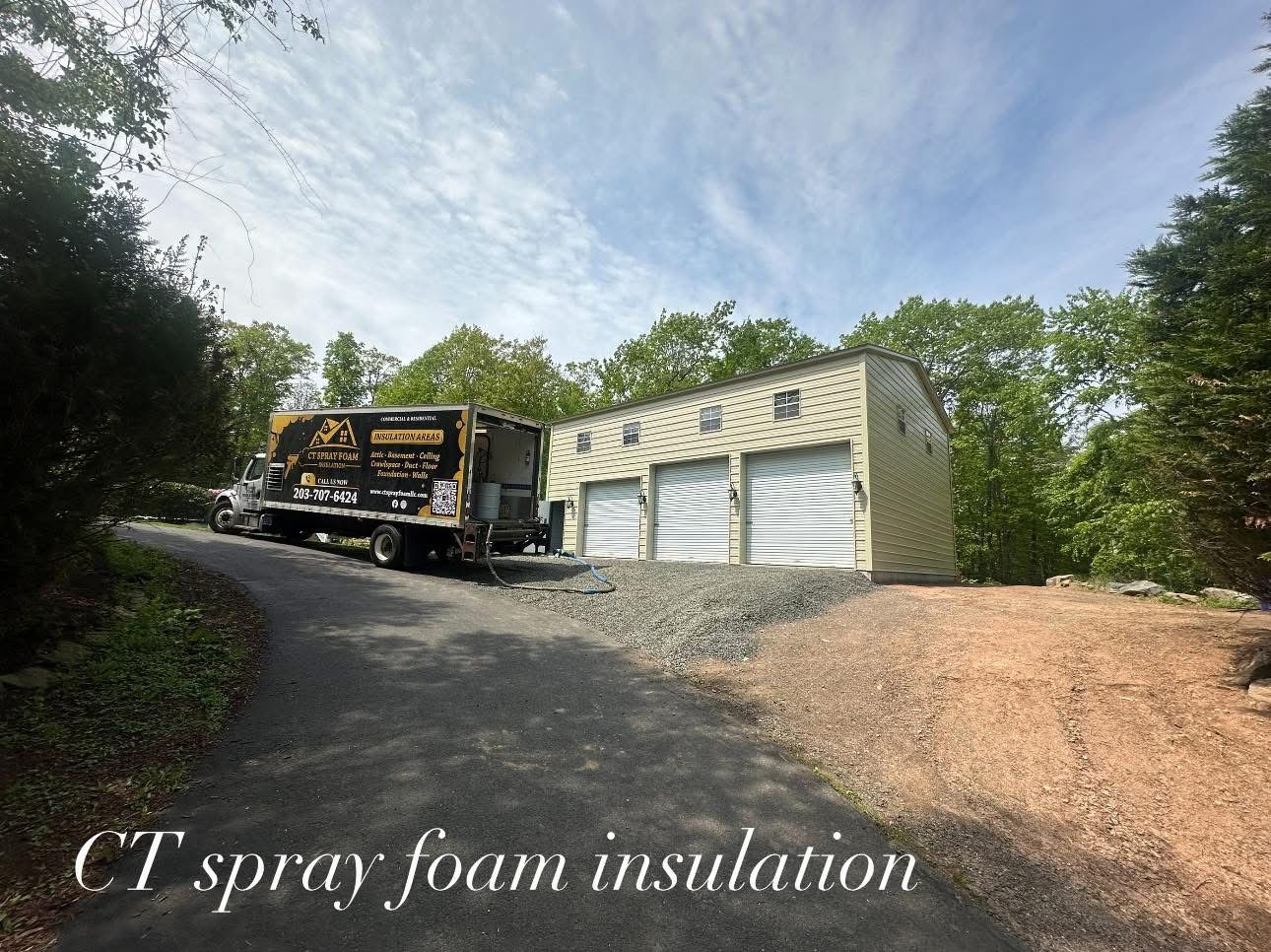 A truck next to a three-bay garage, likely for spray foam insulation, under a blue sky.