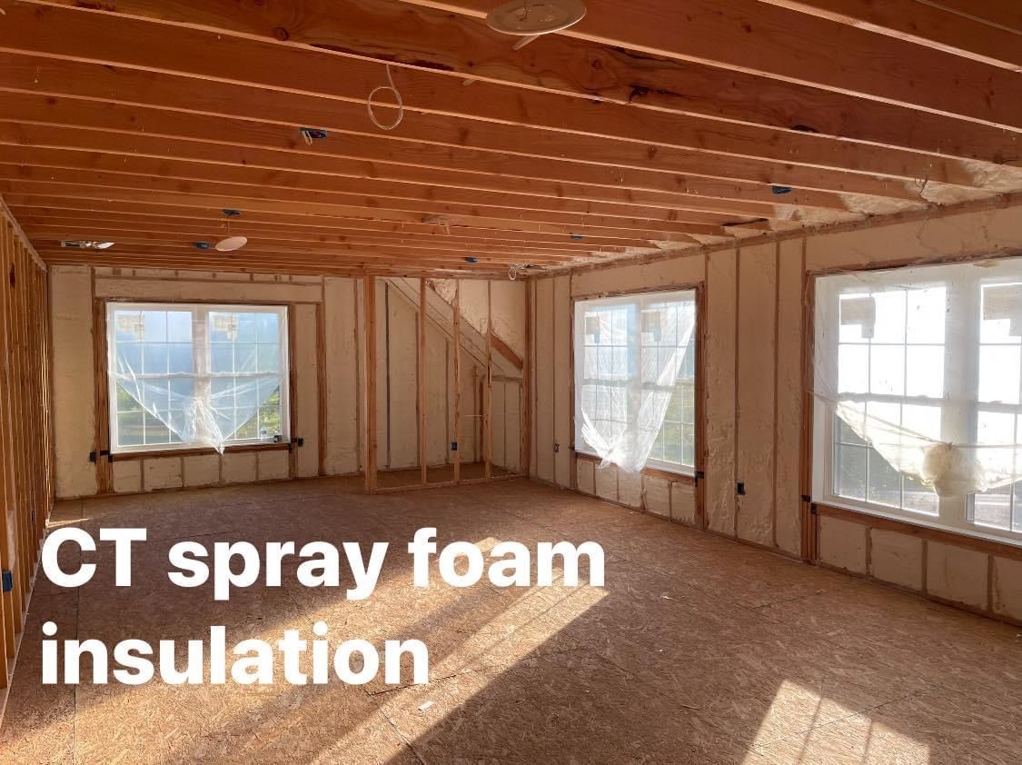 Interior room with exposed wood framing and spray foam insulation. Three windows.