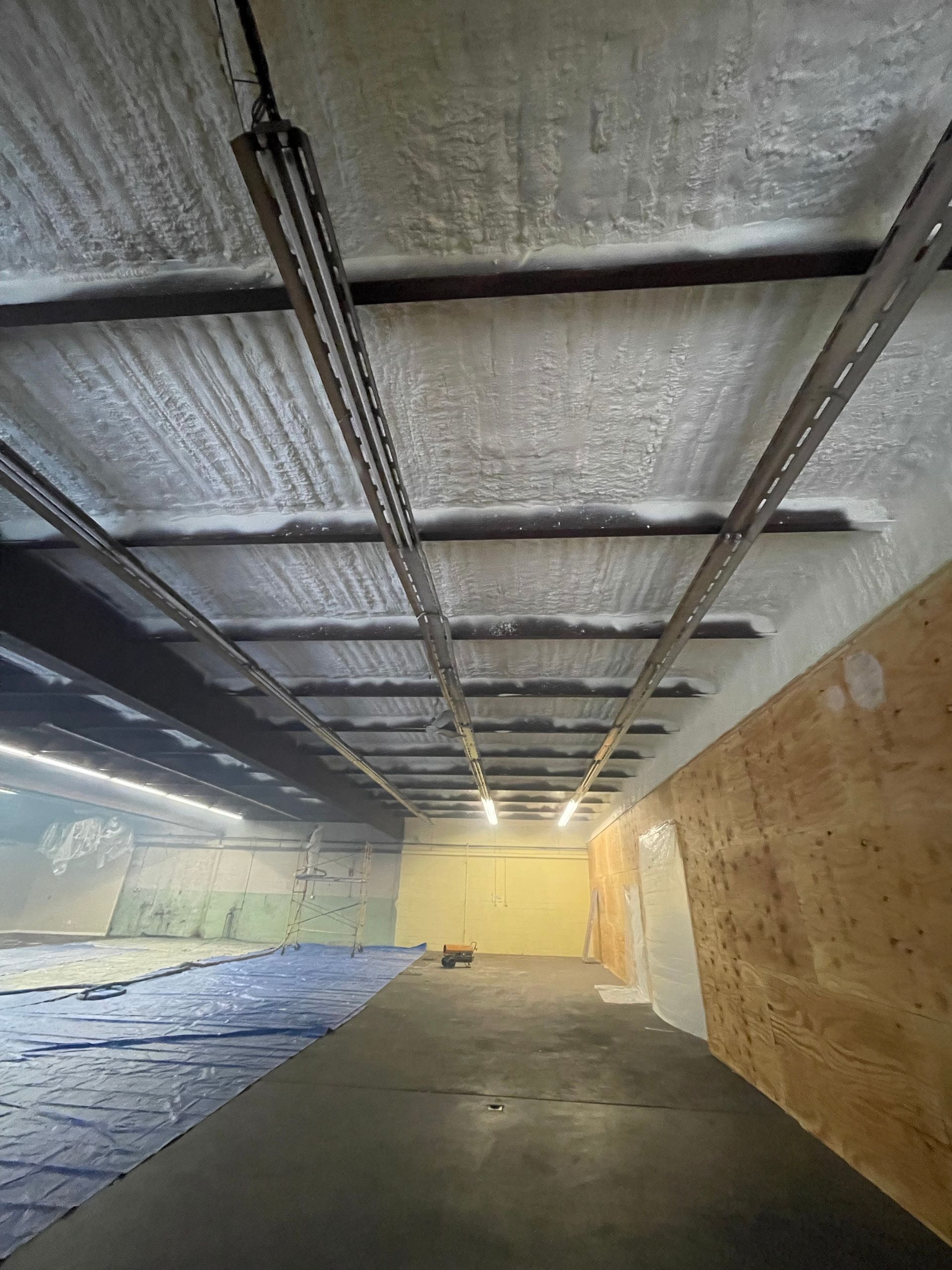 Shooting range interior, showing ceiling with metal supports, targets in the distance, and sound-dampening panels.