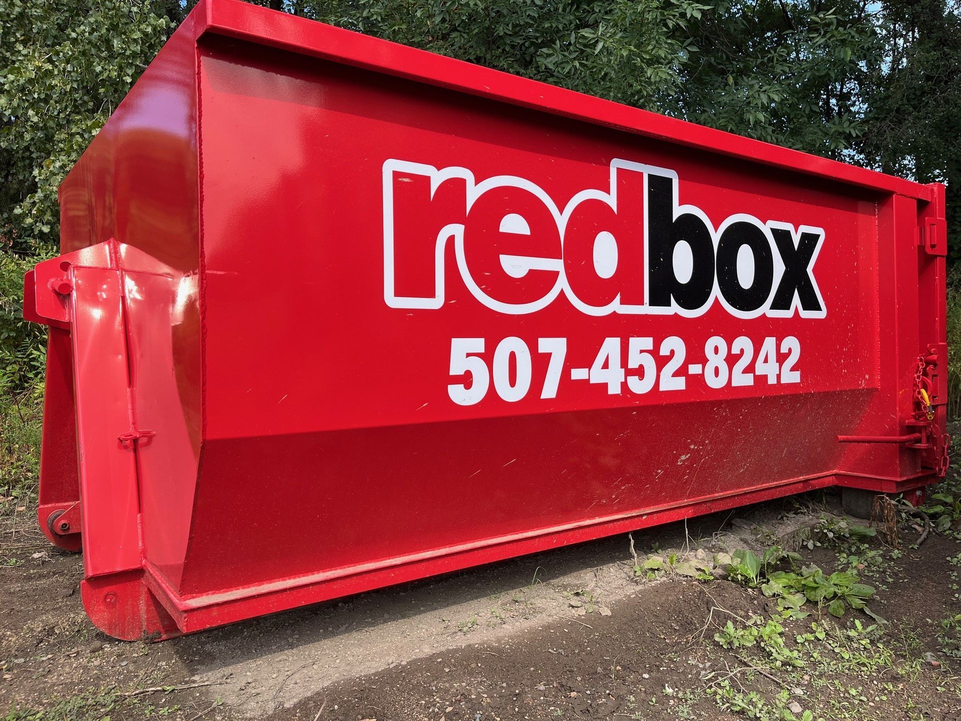 A red dumpster with the word redbox on it