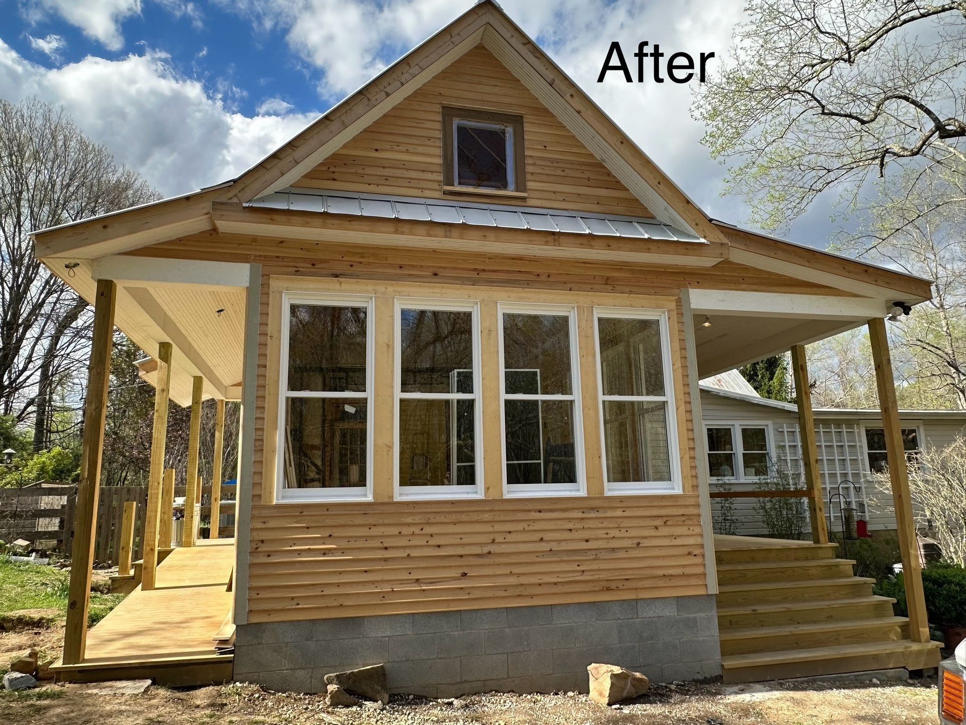 Newly constructed small house with a porch and white framed windows.