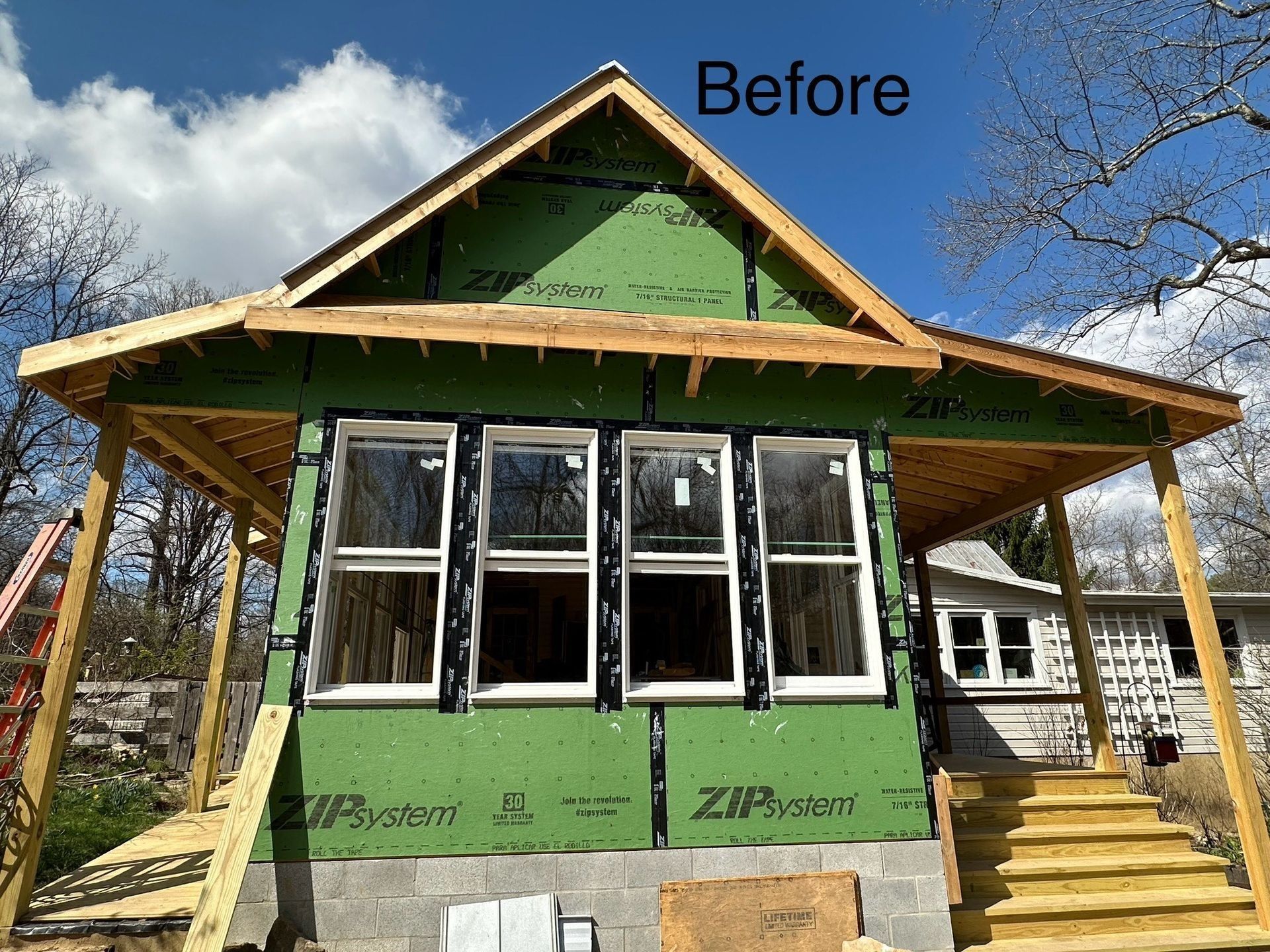 House under construction, green siding, wood frame, new windows, open porch, before picture.