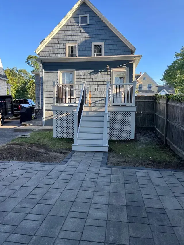 A gray house with a white deck and stairs.