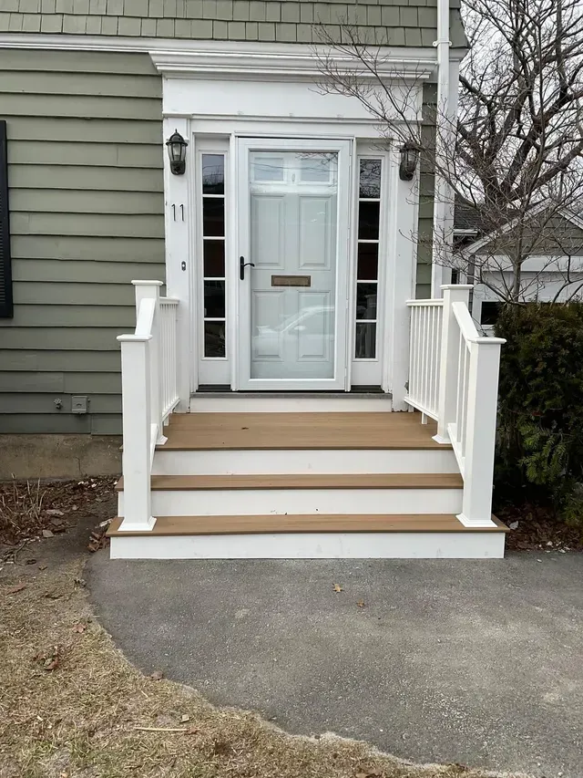 The front door of a house with stairs leading up to it.